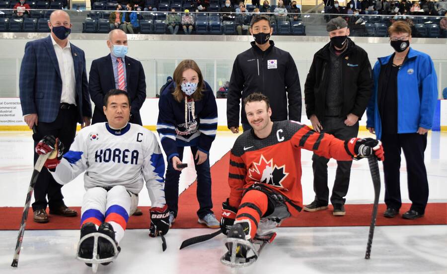 <p>KEVIN MCBAIN, PHOTO</p><p>Ceremonial faceoff. Katie Lear of the South Shore Para Lumberjacks performs the ceremonial face-off prior to game one of the four-game series between Team Canada and Team South Korea Nov. 14. Standing with Lear, from left to right, is Andrew Tanner from the Town of Bridgewater, Team Canada Manager Marshall Starkman, South Korean Coach Min Su Han, Town of Bridgewater Mayor David Mitchell and Municipality of the District of Lunenburg Mayor Carol Bolivar-Getson. In their sleds from left is Team South Korea Captain Jong-Ho Jang and Team Canada Captain Tyler MacGregor.</p>