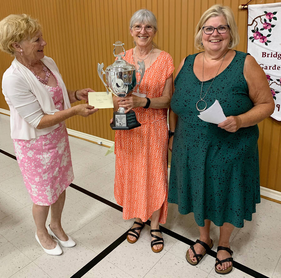 <p>CONTRIBUTED PHOTO</p><p>Bridgewater Garden Club President Evelyn Snyder (left) presents the best overall display award to Susan Gilmour at the club&#8217;s annual show and tea. On the far right is Vicki Trenholm, flower show chair.</p>