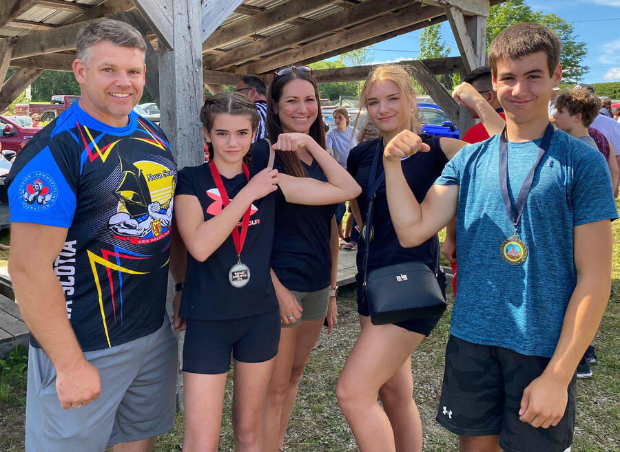 <p>Meet Shane Elliott (left) and his family of arm wrestlers. The Brookfield family took home many medals from the community fair competition, but there are also two national champions among them. Beside Shane is Kylie, who won the 13 and under 40 kg girls&#8217; national championships in the left and right hand in July&#8217;s national championship held in Truro. Sister Autumn (second from right), won the 14-18-year-old, 60 kg title in both the left and right arms. Brother Hunter is no slouch either, winning third place at the nationals in the 14-18 age category and 60 kg weight division in both the left and right. Mother, Mareshah, finished first third in the left-arm in the ladies&#8217; 80 kg class at nationals and fifth in the right-arm. All four took home at least one gold medal. Father Shane, also competed and finished fifth in his division.</p>