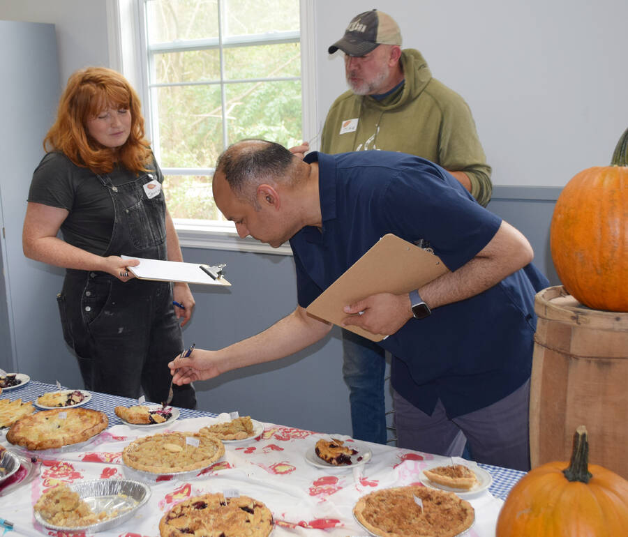 <p>Judge Sachin Seth, of Halifax, a 2018 Finalist in the Great Canadian Baking Show, takes a closer look at one of the pies during the first pie contest and sale held during the Mahone Bay Scarecrow and Antiques Festival, Sept. 30. Also, judging were local celebrities Jenna Barrie and Mike Bishop.</p>